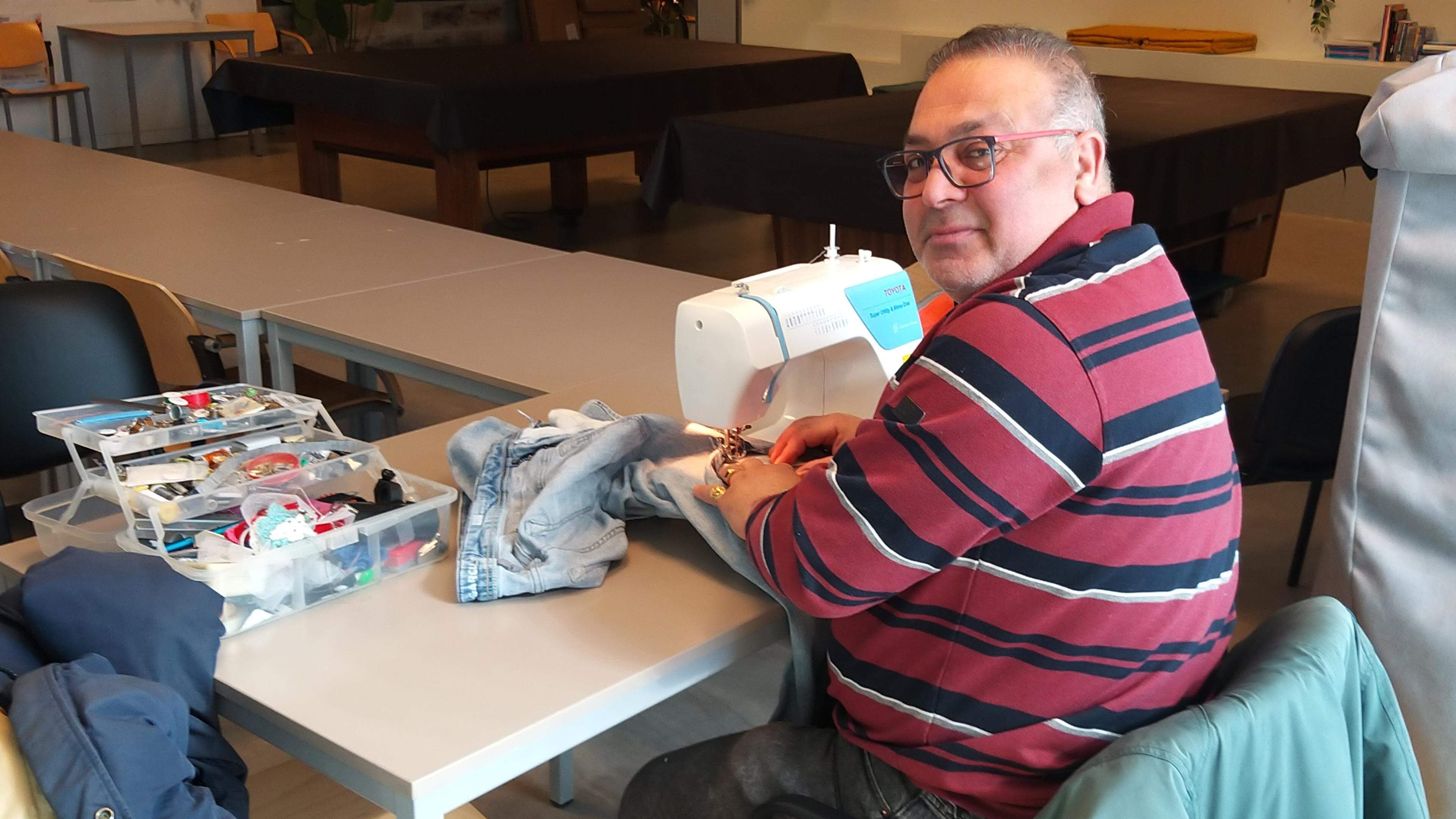 Kleermaker Bahman knapt elke dinsdag kapotte kleding op in buurthuis De Stek in Velsen-Noord. ’Als d